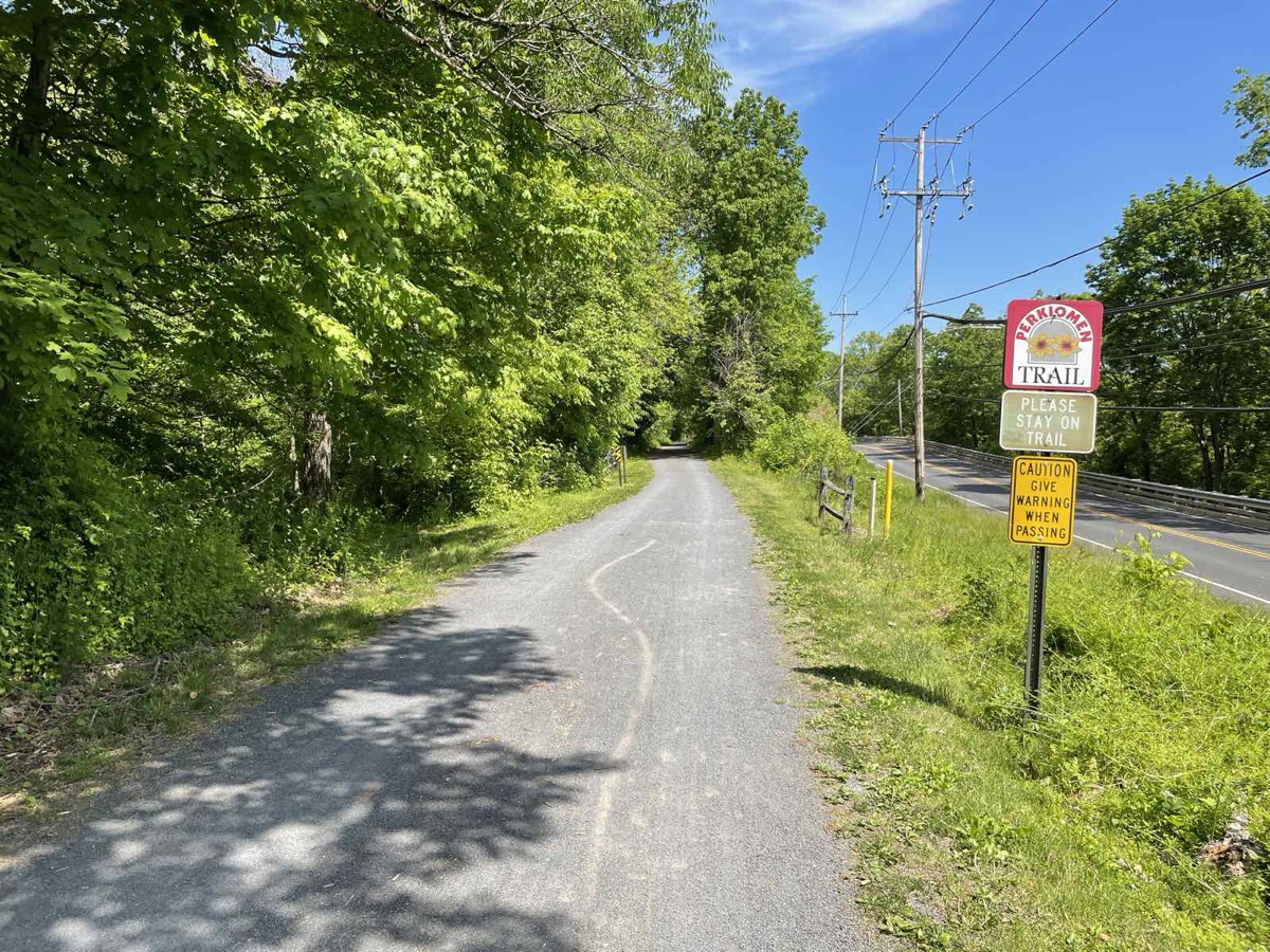 The paved Perkiomen Trail under a green tree canopy, Lower Providence Township, Montgomery County PA